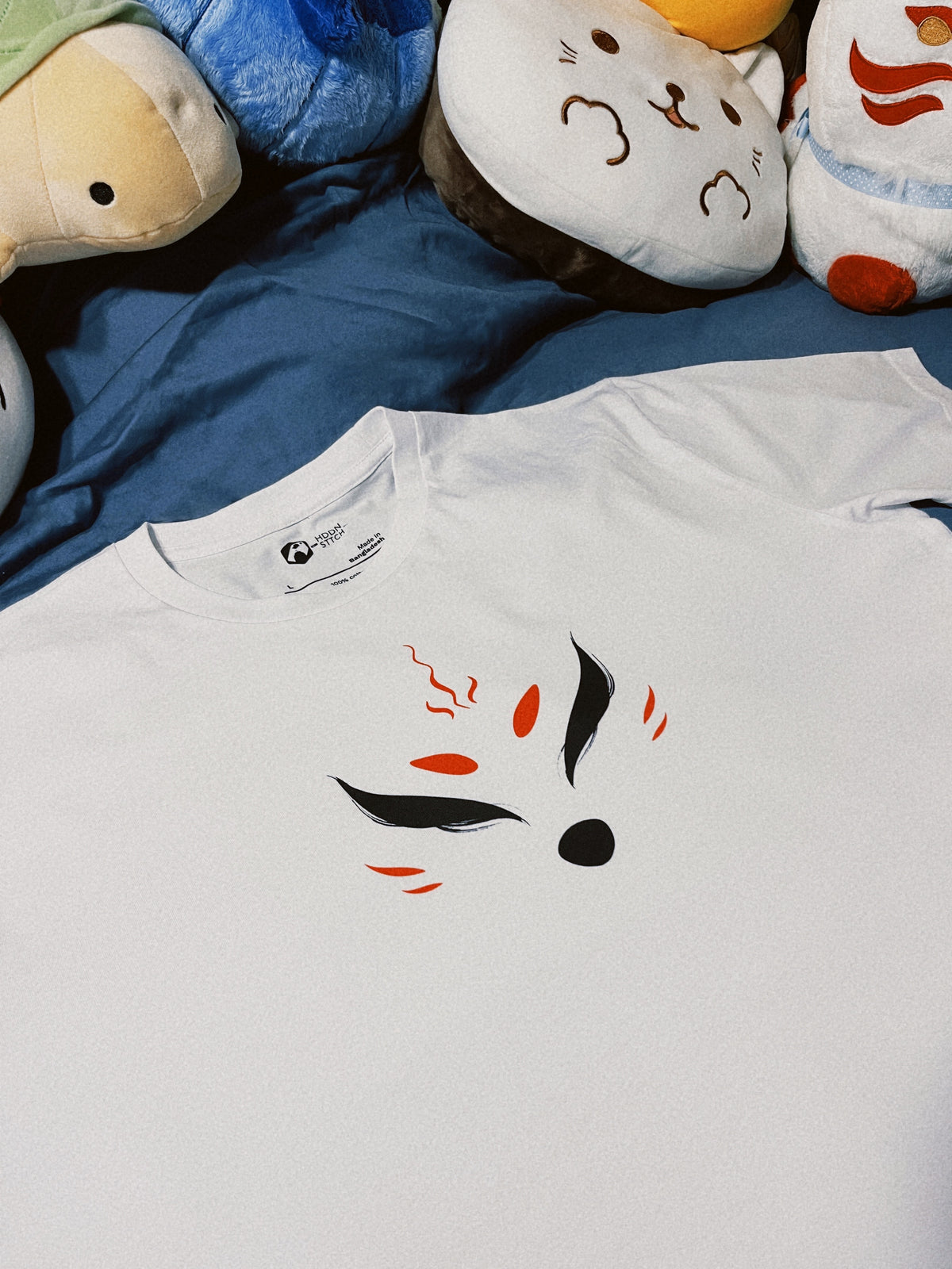 Close-up of a premium white cotton T-shirt featuring black and red markings of a kitsune