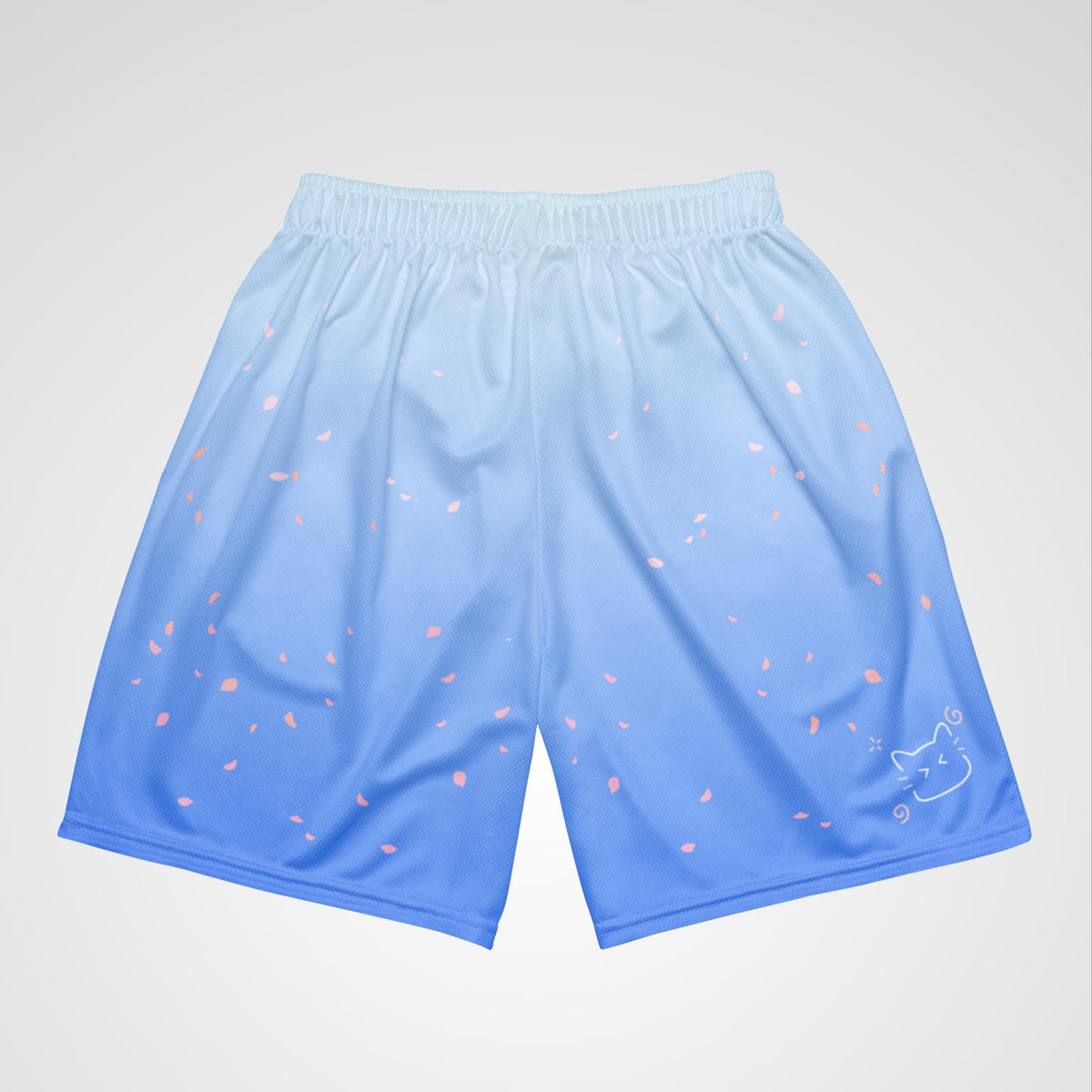 Top view of blue shorts with floral and cat designs on a light gray background