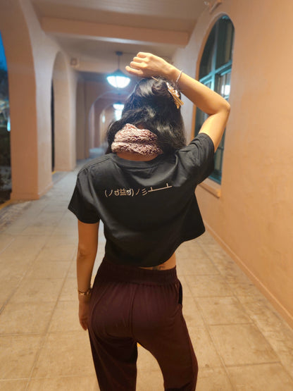 Table Flip Emoticon Crop Top worn by female model in a sandy-colored hallway